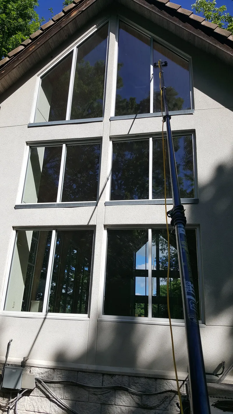 A water-fed pole reaching the top row of a three-row wall of gable windows.