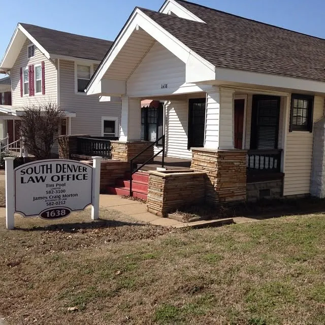 A small office in a converted house, with a sign on the front lawn.