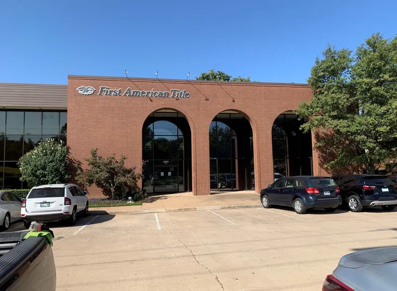 A brick office building with tall arched windows at the entrance.