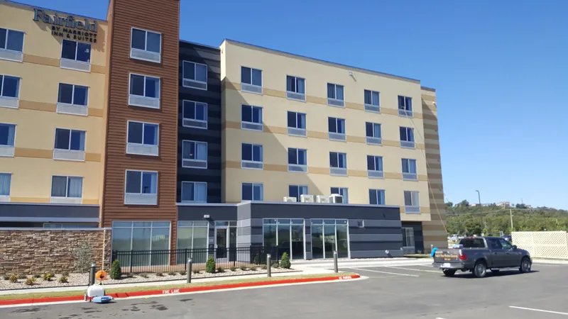 A four-story hotel with rows of windows above its parking lot.